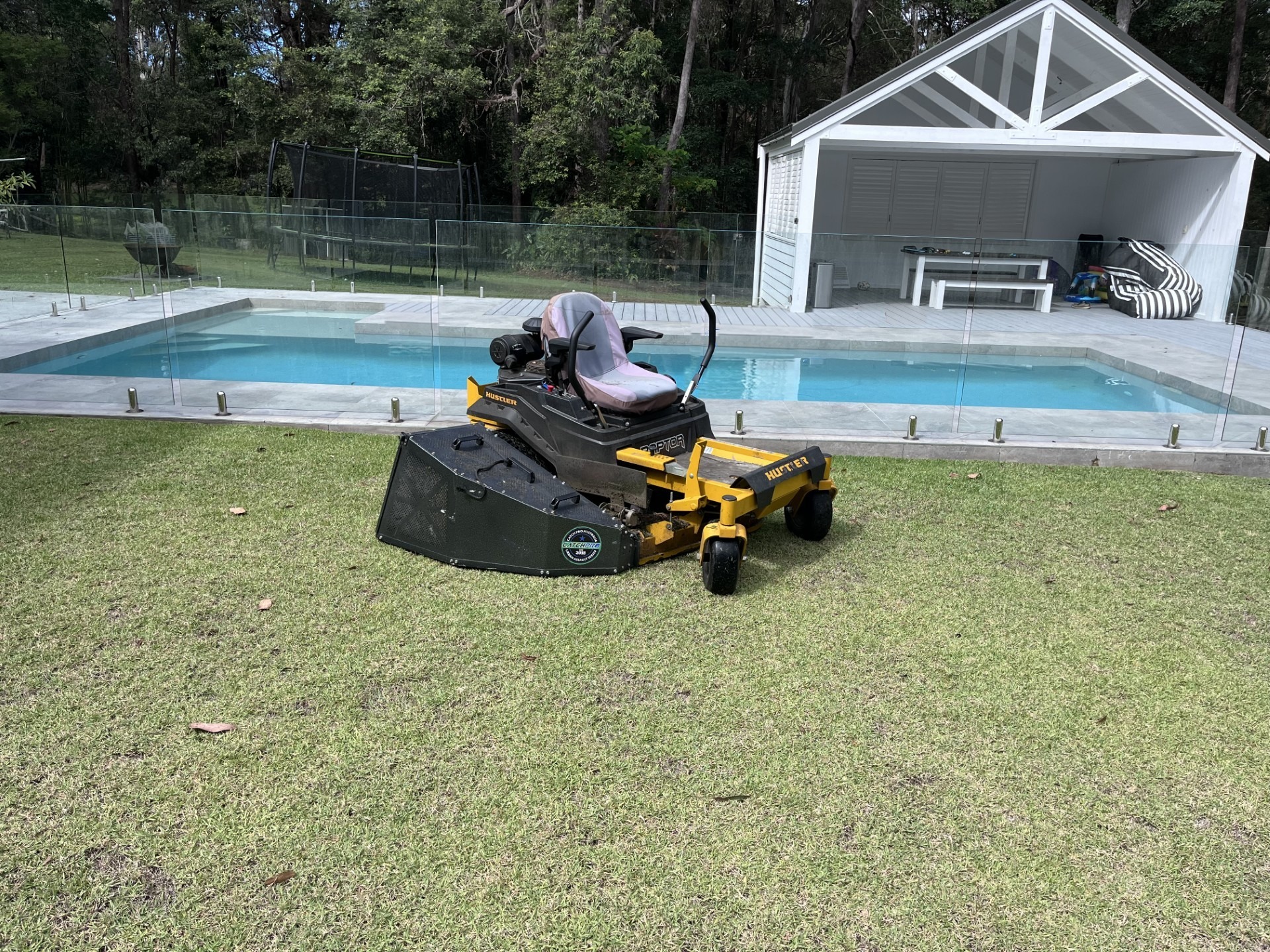 Mary Valley Mowing ride-on mower on a freshly mown lawn beside a pool